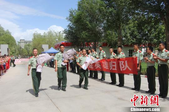 部隊(duì)官兵們迎接出院歸來的李運(yùn)飛(中)和其他消防戰(zhàn)士?！⊥粲?攝