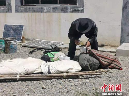 圖為黨確桑布展示以前巡邊時(shí)要帶的東西。 謝藝觀 攝