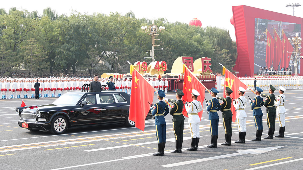 習(xí)近平驅(qū)車行進(jìn)至黨旗、國旗、軍旗前，向旗幟行注目禮