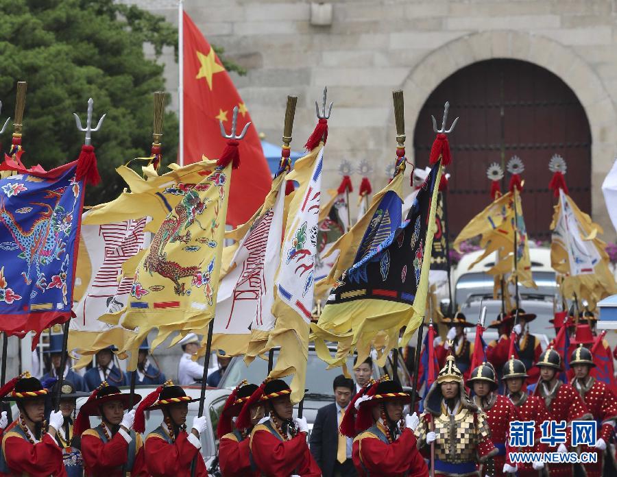 7月3日，韓國總統(tǒng)樸槿惠在青瓦臺總統(tǒng)府舉行隆重儀式，歡迎中國國家主席習(xí)近平對韓國進(jìn)行國事訪問。這是習(xí)近平的車隊(duì)在身著民族服裝的韓國禮儀隊(duì)伍引導(dǎo)下駛?cè)肭嗤吲_。新華社記者丁林?jǐn)z  